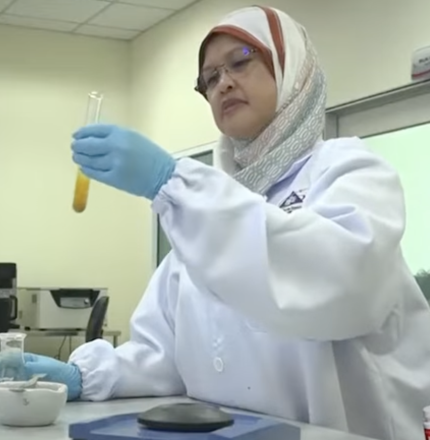 Penyelidik UMT di makmal memegang tabung uji berisi ekstrak herba